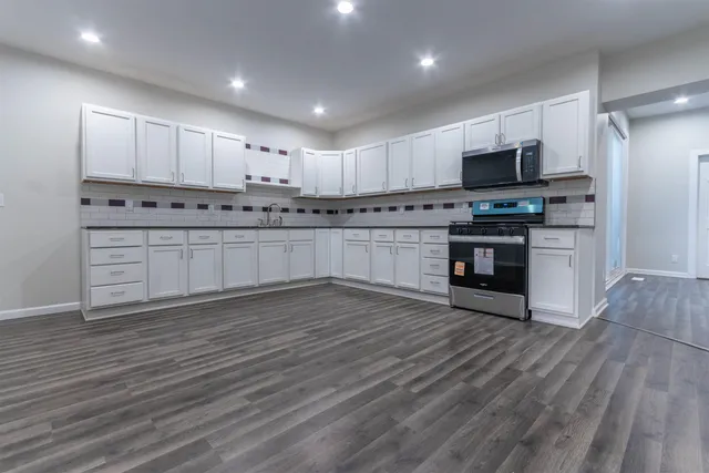 a kitchen with stainless steel appliances a stove top oven and a sink