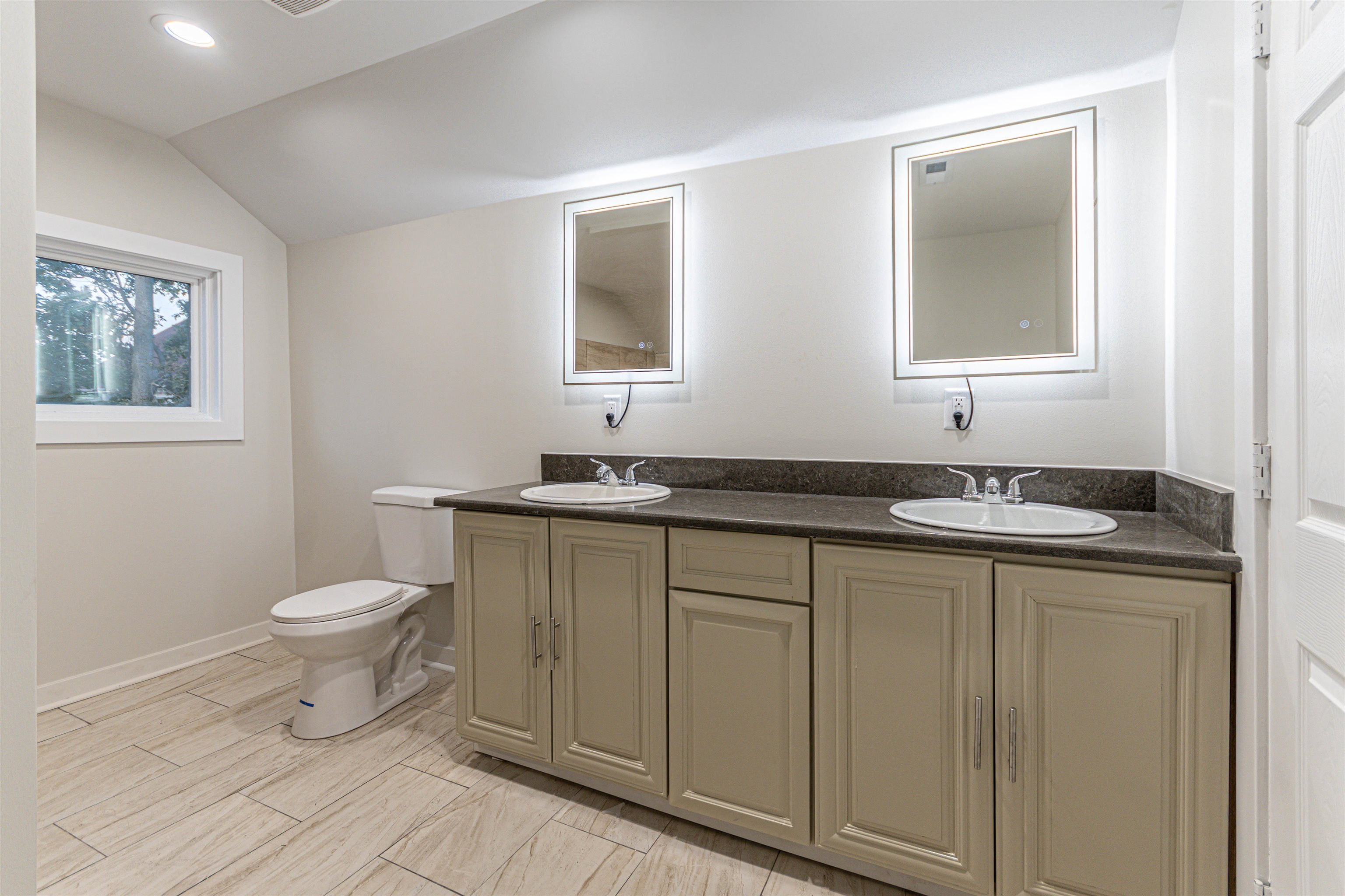 407 Allen Street Belvidere, IL 61008 - Photo 21 of 32 a bathroom with a granite countertop toilet a sink and a mirror