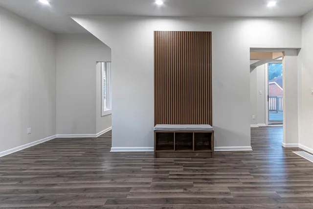 an empty room with wooden floor and windows