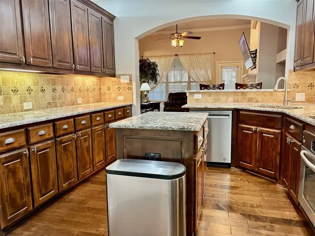 a kitchen with stainless steel appliances granite countertop a sink stove and cabinets