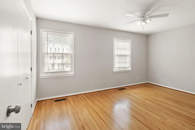 a view of an empty room with wooden floor