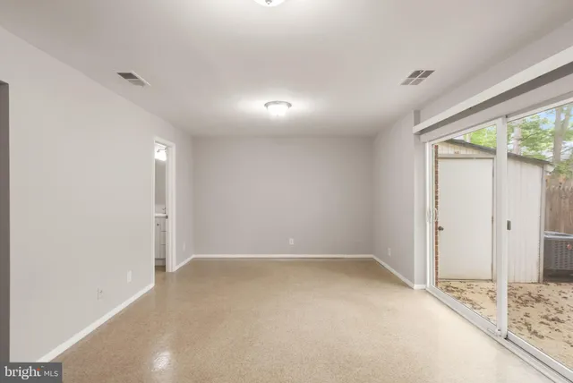 an empty room with an entryway and fan