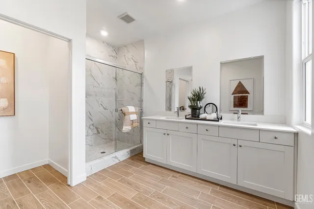 a spacious bathroom with a shower sink and mirror