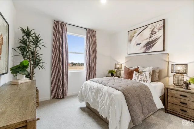 a bedroom with a large bed and a potted plant