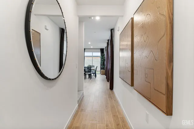 a view of a hallway with wooden floor and staircase