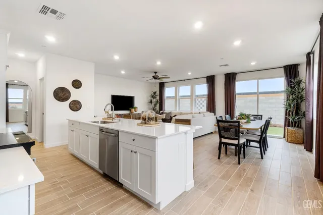a large white kitchen with lots of counter space dining table and chairs