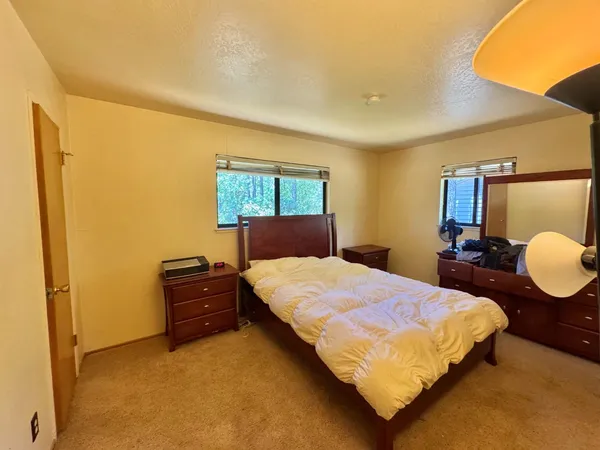 a bedroom with a bed lamps and a mirror