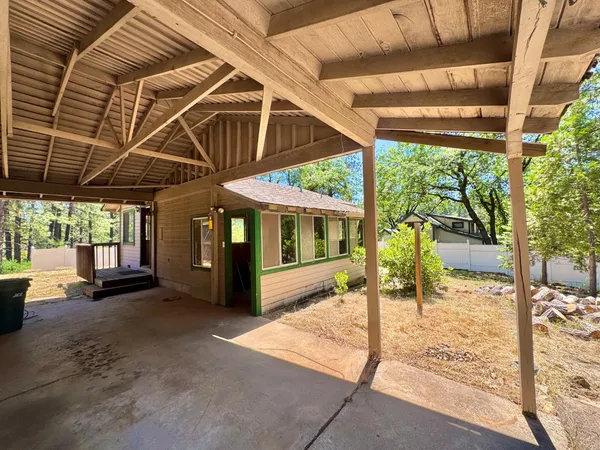a porch with a table and chairs next to a yard
