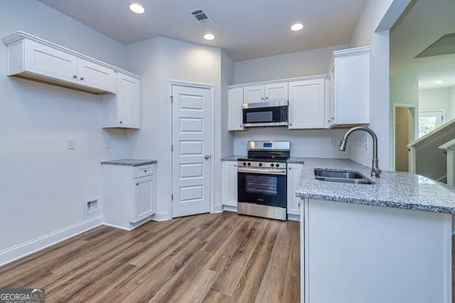 a kitchen with stainless steel appliances granite countertop a sink stove and refrigerator