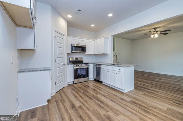a kitchen with stainless steel appliances sink refrigerator and microwave