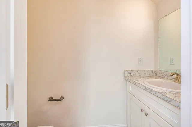 a bathroom with a granite countertop sink and a white vanity