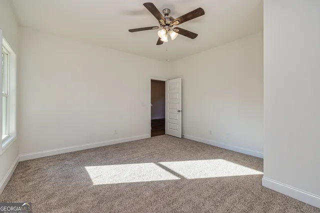 an empty room with closet and a ceiling fan
