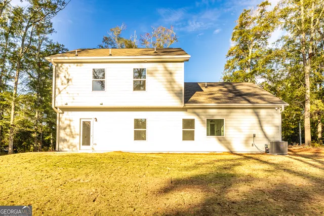 a view of a white house with a large tree