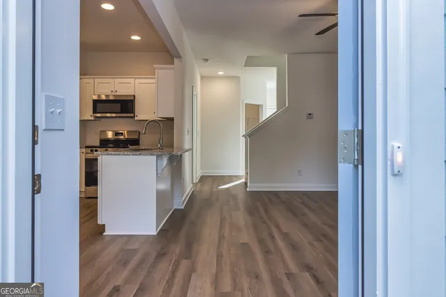 a view of a kitchen from the hallway with a sink