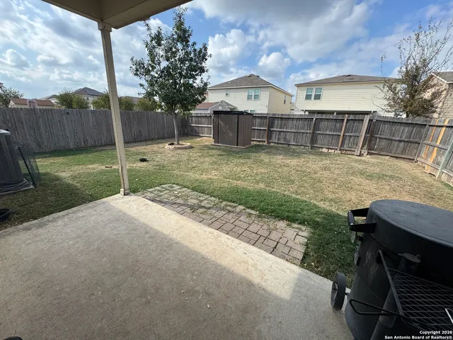 a view of a house with a yard and wooden fence