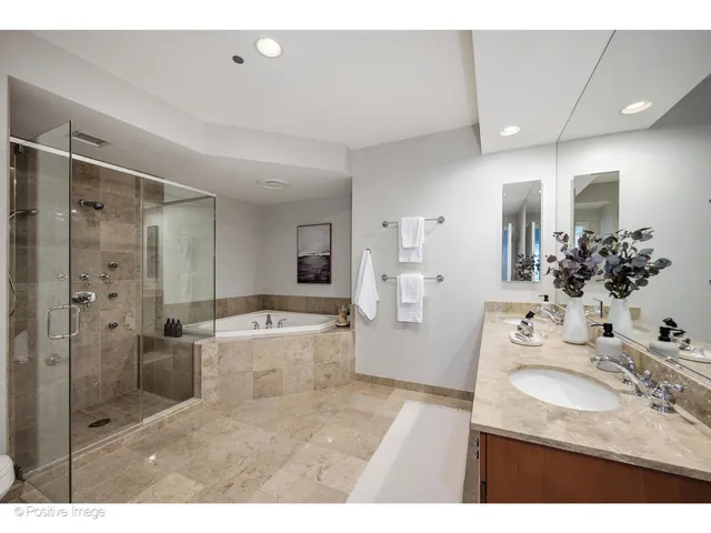 a bathroom with a tub sink mirror and shower