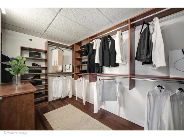 a view of walk in closet with clothes and shoes