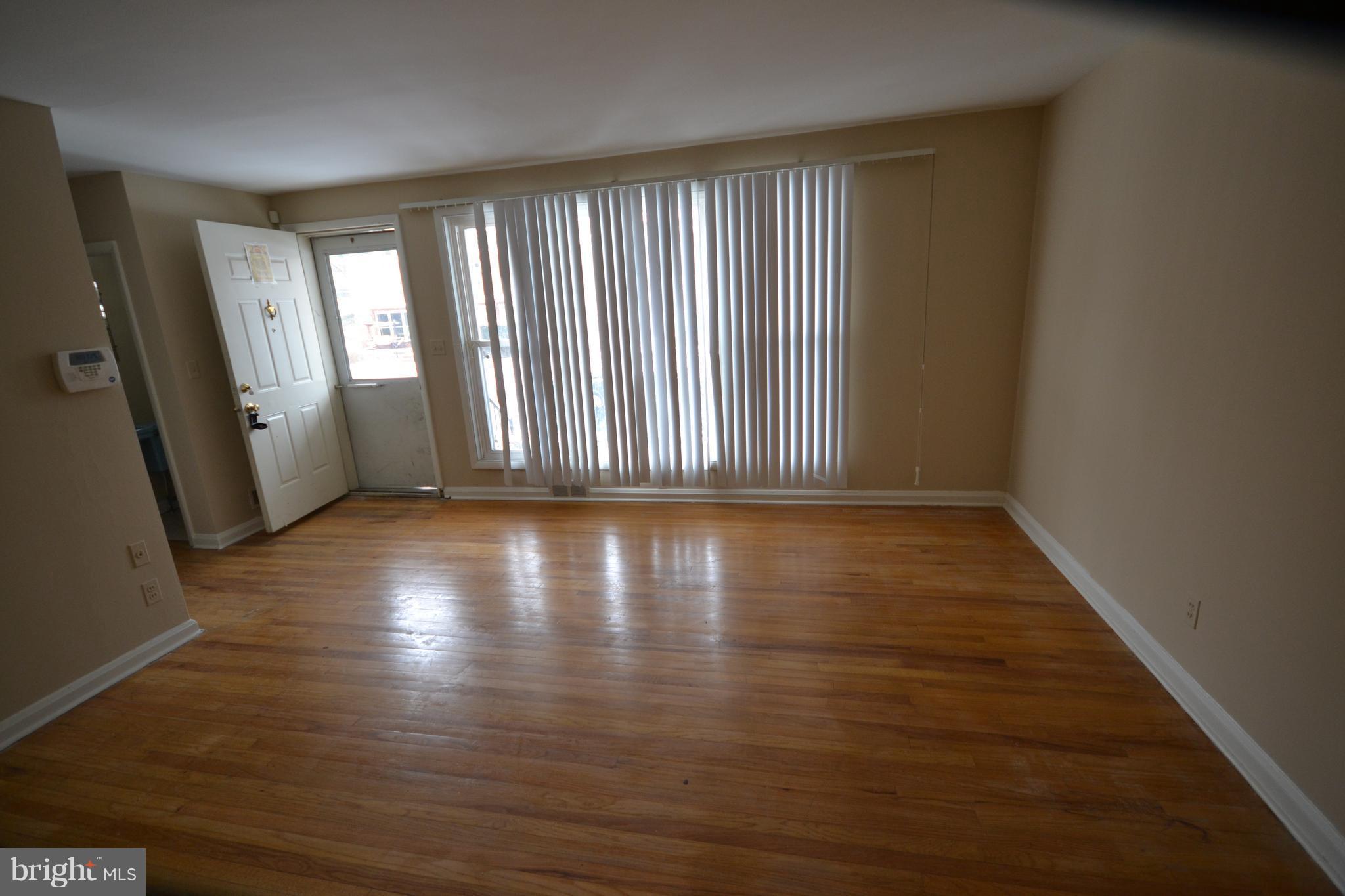 7122 Boxford Road Baltimore, MD 21215 - Photo 2 of 14 an empty room with wooden floor and windows