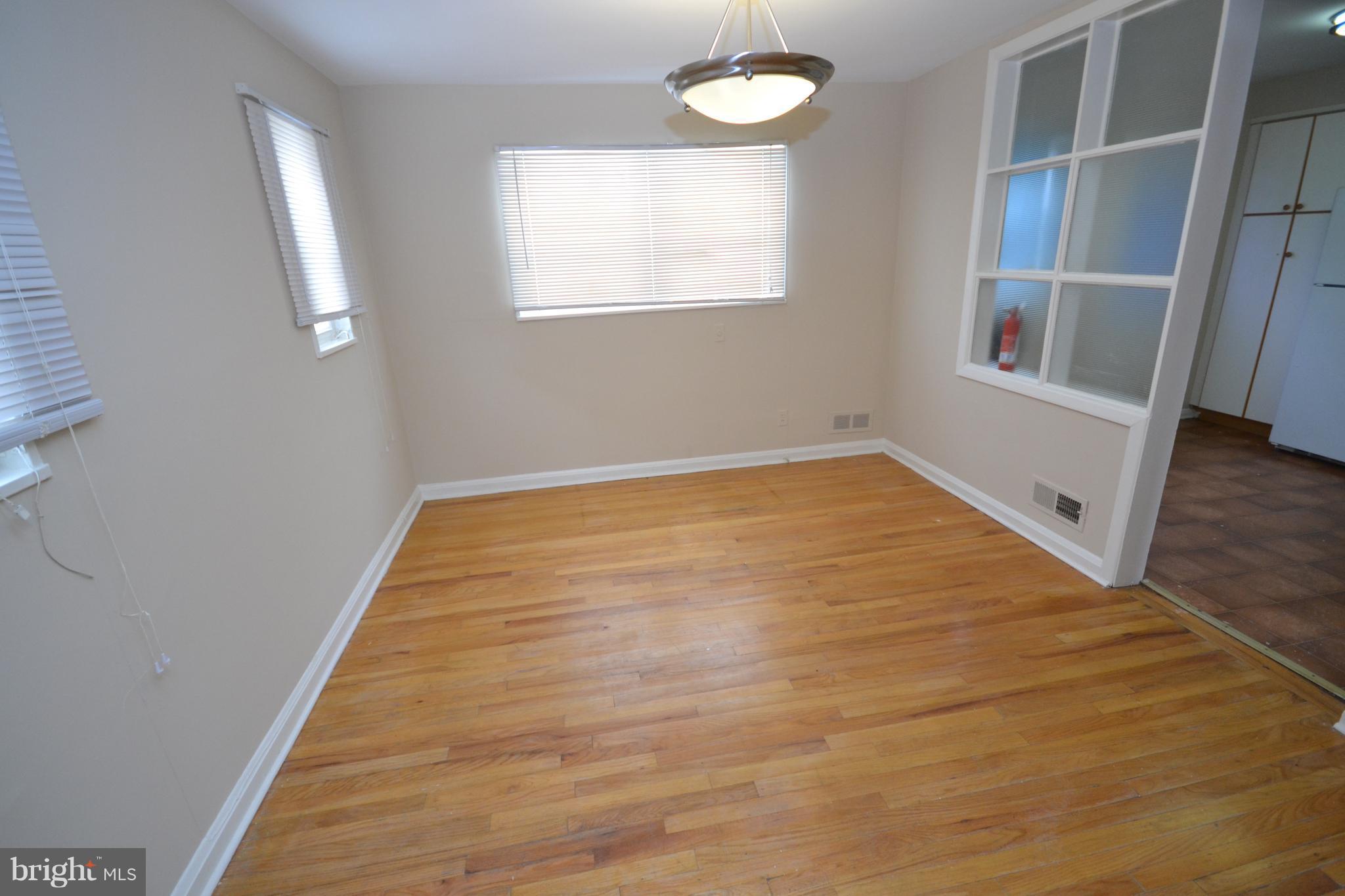 7122 Boxford Road Baltimore, MD 21215 - Photo 4 of 14 a view of an empty room with wooden floor and a window
