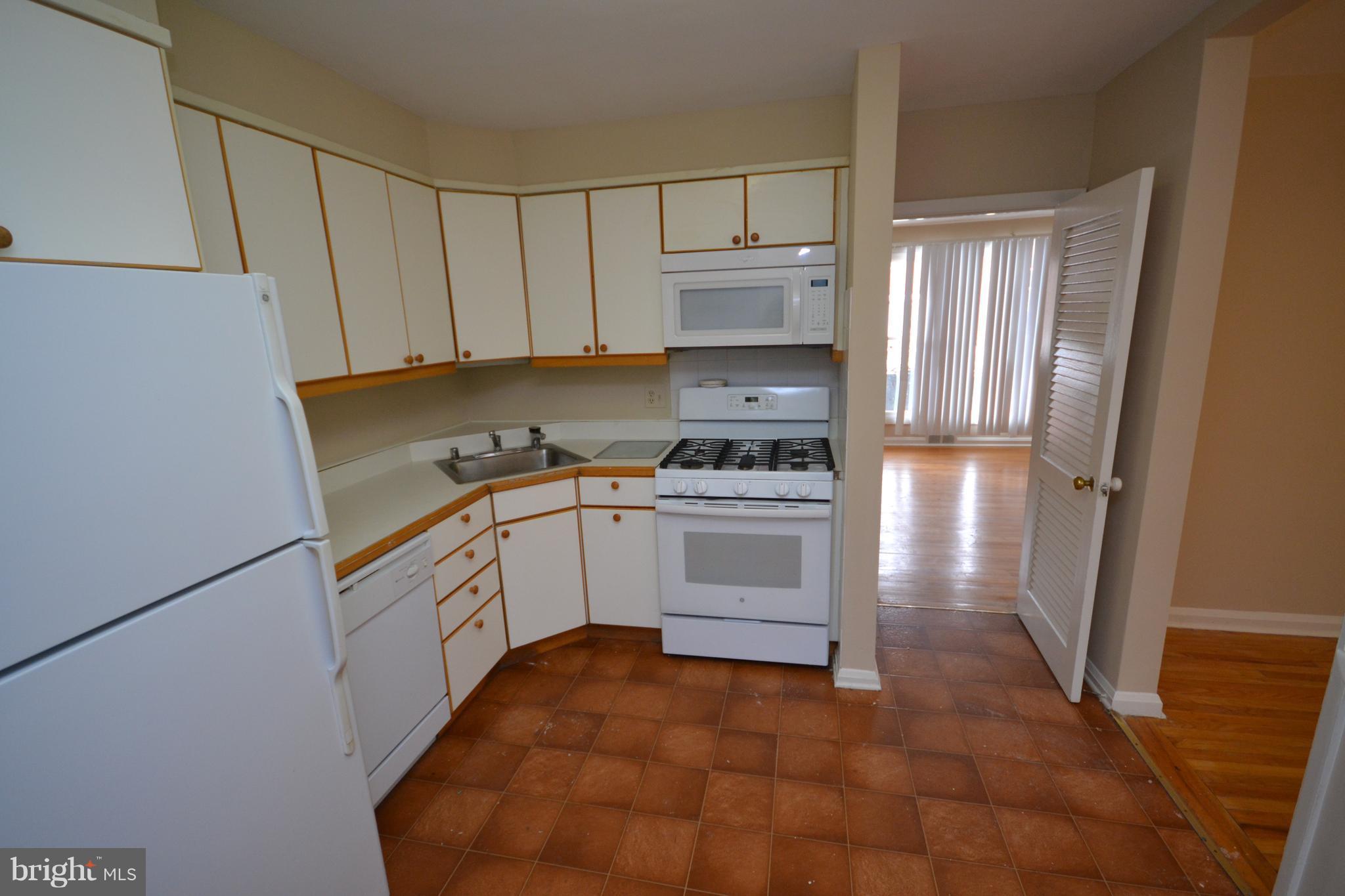 7122 Boxford Road Baltimore, MD 21215 - Photo 5 of 14 a kitchen with white cabinets and white appliances