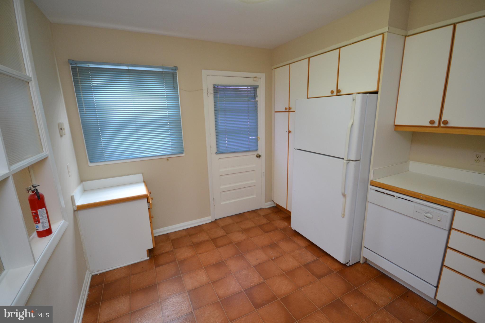 7122 Boxford Road Baltimore, MD 21215 - Photo 6 of 14 a view of a kitchen with refrigerator and white cabinets