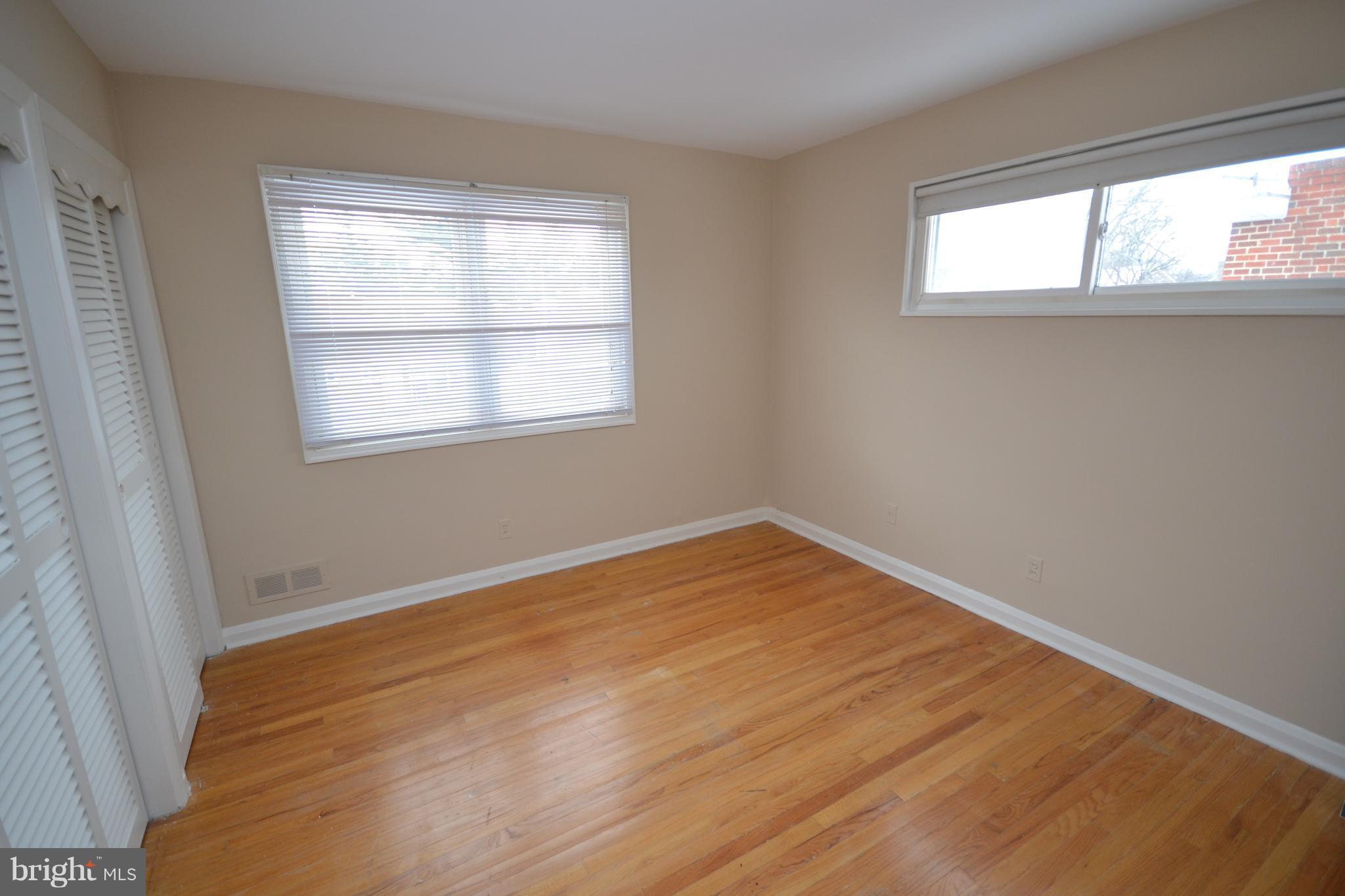 7122 Boxford Road Baltimore, MD 21215 - Photo 8 of 14 an empty room with wooden floor and windows