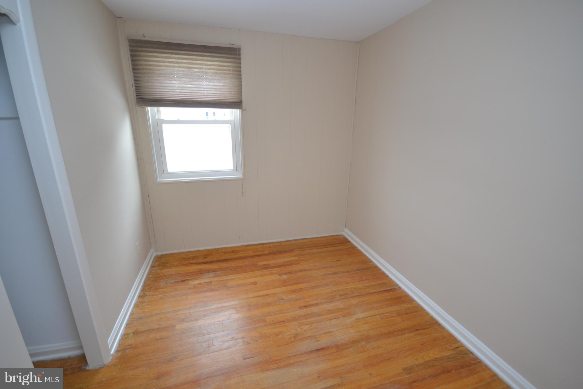 7122 Boxford Road Baltimore, MD 21215 - Photo 9 of 14 a view of an empty room with wooden floor and a window