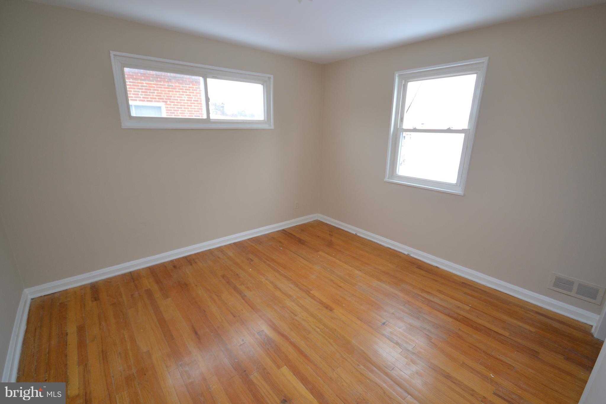 7122 Boxford Road Baltimore, MD 21215 - Photo 10 of 14 an empty room with wooden floor and windows