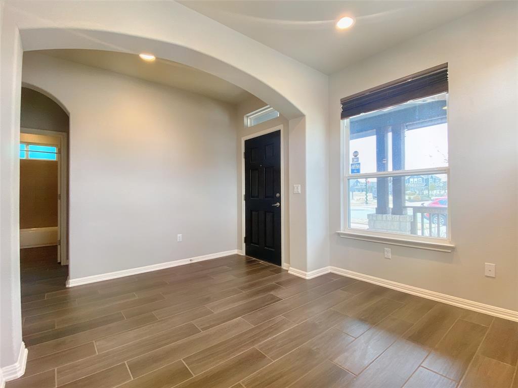 8901 Panhandle Drive Austin, TX 78747 - Photo 4 of 21 Spacious interior featuring wood-finish tile flooring, arched doorways, a paneled entry door, and recessed lighting