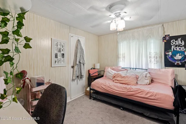 a bedroom with a bed and a large window