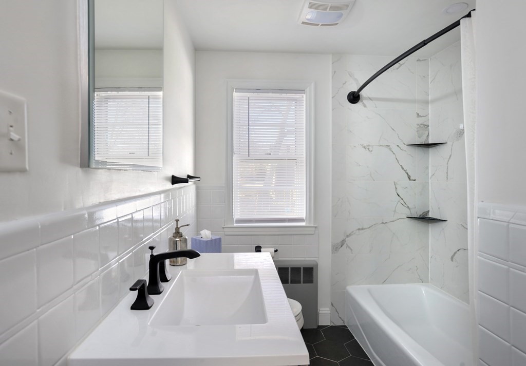 7 Spring Street Weymouth, MA 02188 - Photo 13 of 18 a bathroom with a sink a bathtub and a shower