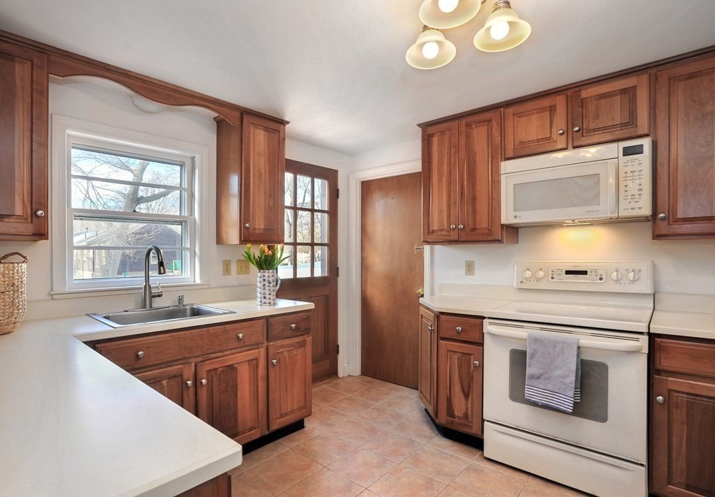 7 Spring Street Weymouth, MA 02188 - Photo 8 of 18 a kitchen with stainless steel appliances granite countertop a sink stove and microwave