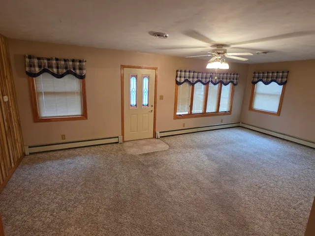 an empty room with windows and chandelier