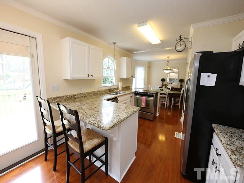 6 Striding Ridge Court Durham, NC 27713 - Photo 8 of 25 a kitchen with stainless steel appliances granite countertop table chairs and a refrigerator