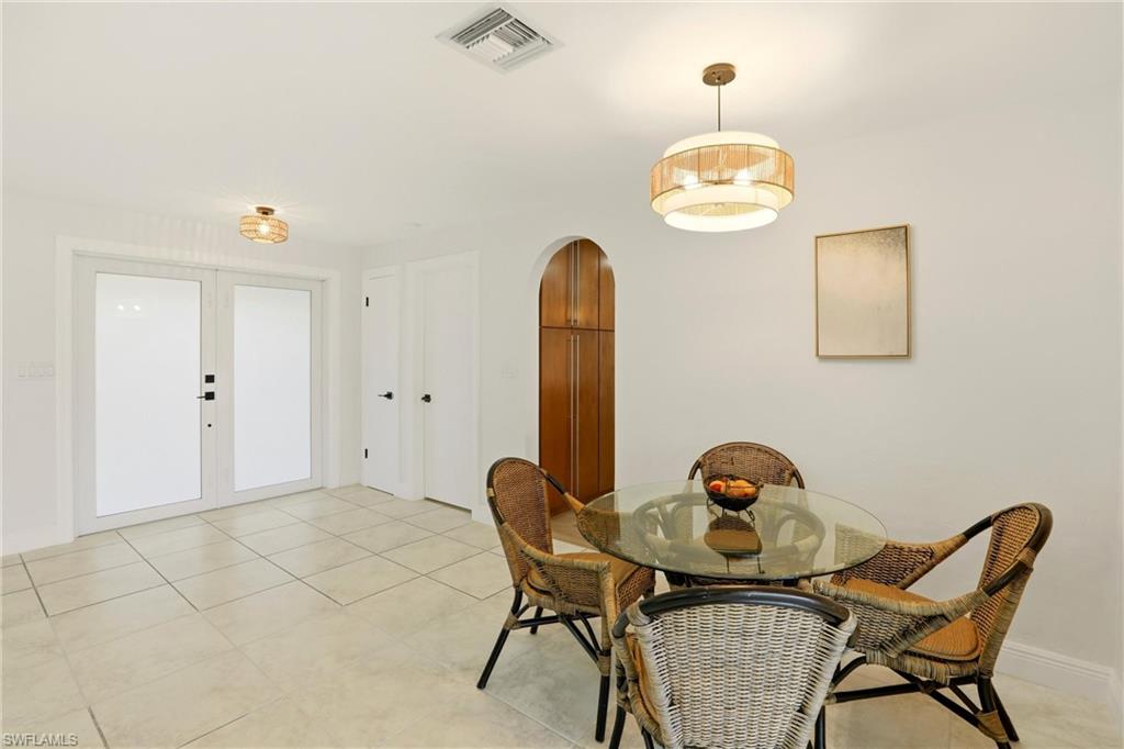 339 Landmark Street Marco Island, FL 34145 - Photo 10 of 50 Dining space with french doors, arched walkways, and light tile patterned floors