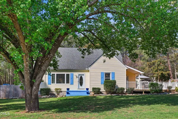 a front view of a house with a yard and trees