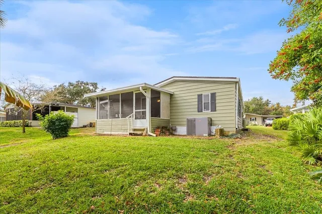 a view of a house with a big yard and large trees