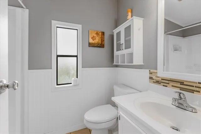 a bathroom with a toilet sink and mirror