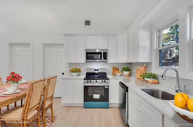 a kitchen with stainless steel appliances a stove a sink a microwave a refrigerator and cabinets