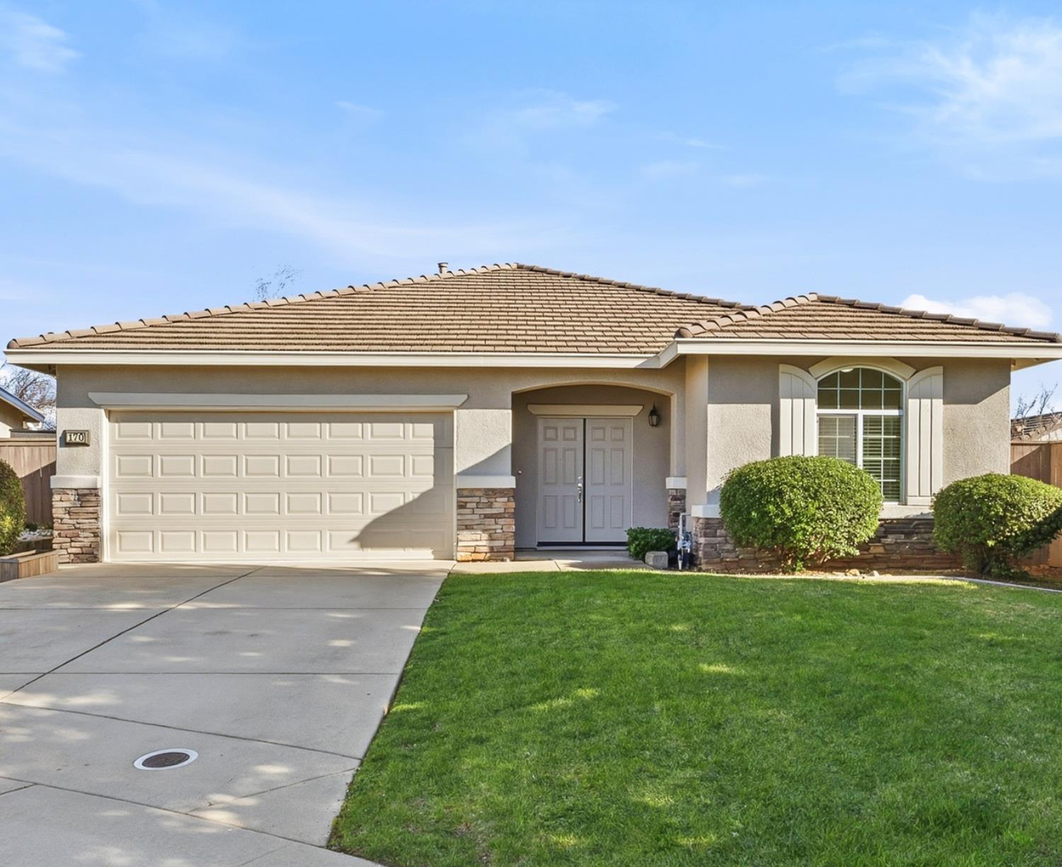 a front view of a house with a yard and garage