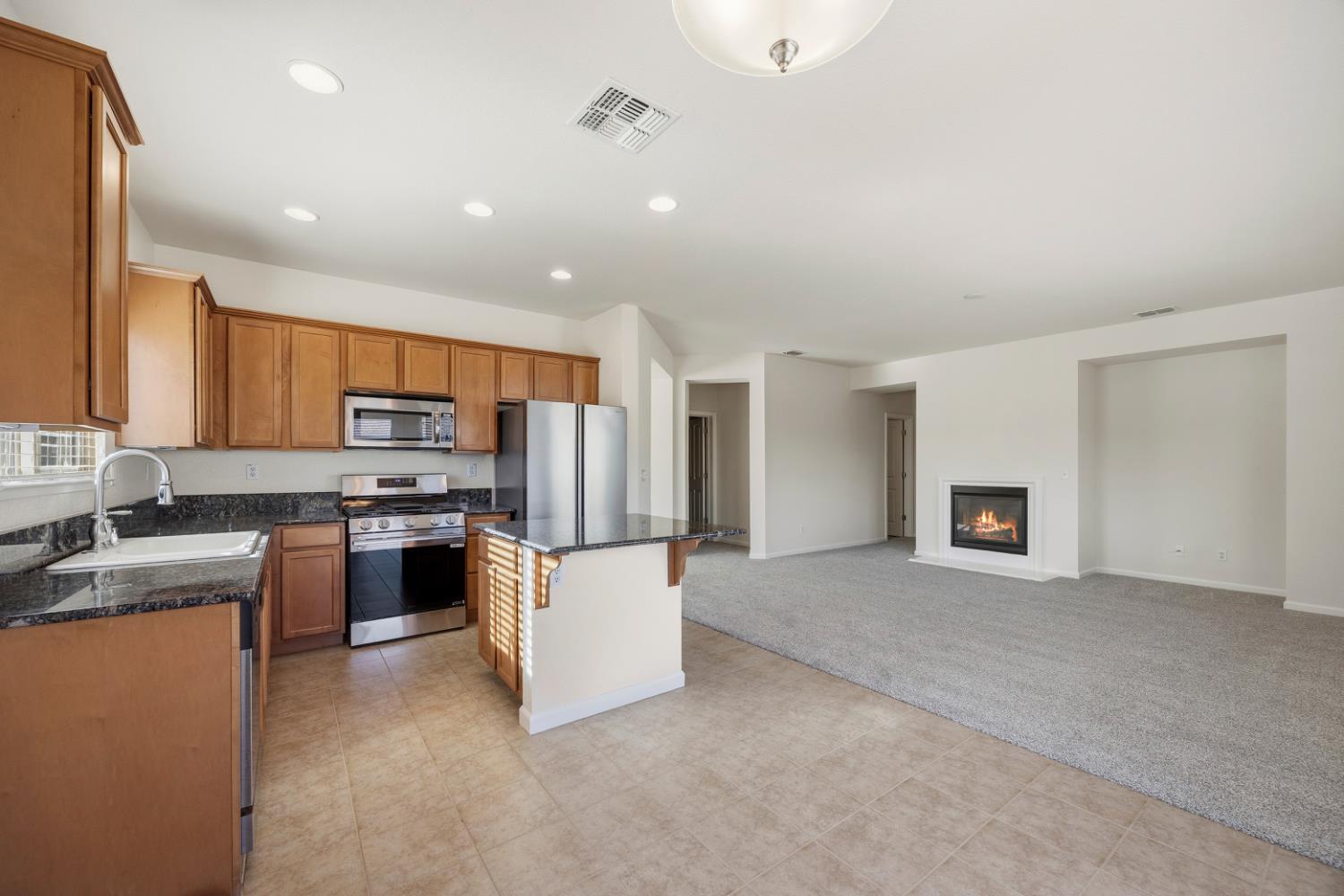 170 Par Court Ione, CA 95640 - Photo 7 of 31 a kitchen with stainless steel appliances granite countertop a stove top oven a sink a refrigerator and white cabinets