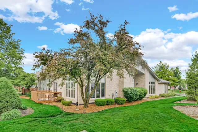 a front view of a house with a garden and trees