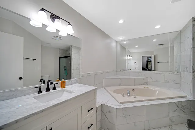 a bathroom with a sink a large mirror and shower
