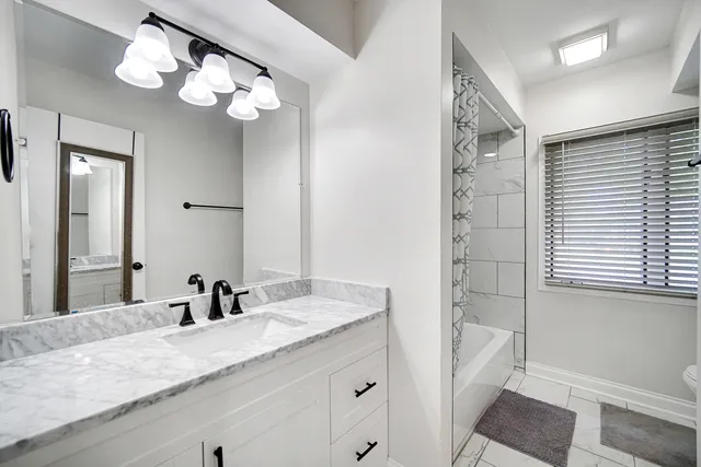a bathroom with a granite countertop sink a toilet and a mirror