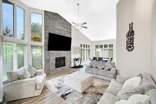 a living room with furniture a flat screen tv and a fireplace