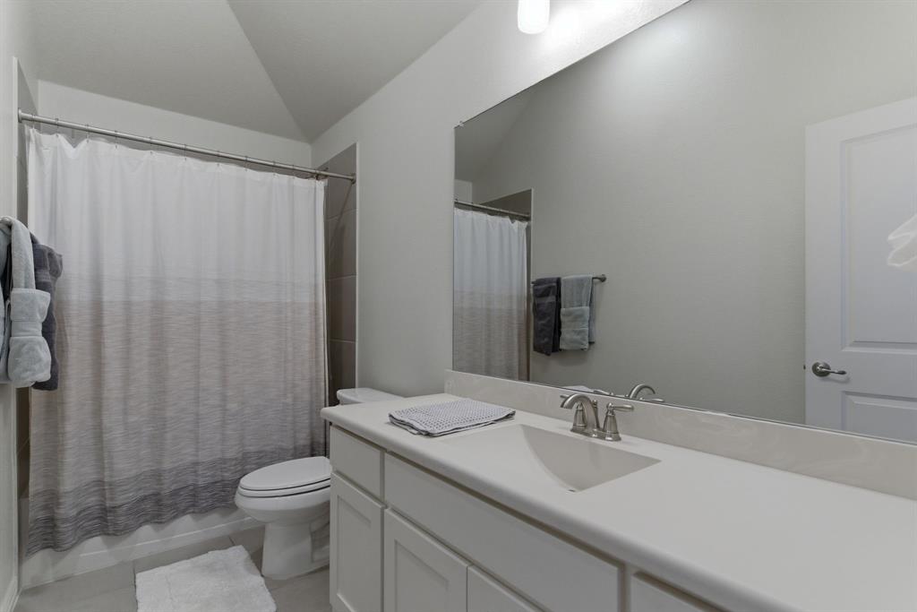 2801 Seabiscuit Road Celina, TX 75009 - Photo 26 of 39 Bathroom with vaulted ceiling, vanity, shower / bath combo, and light tile patterned floors