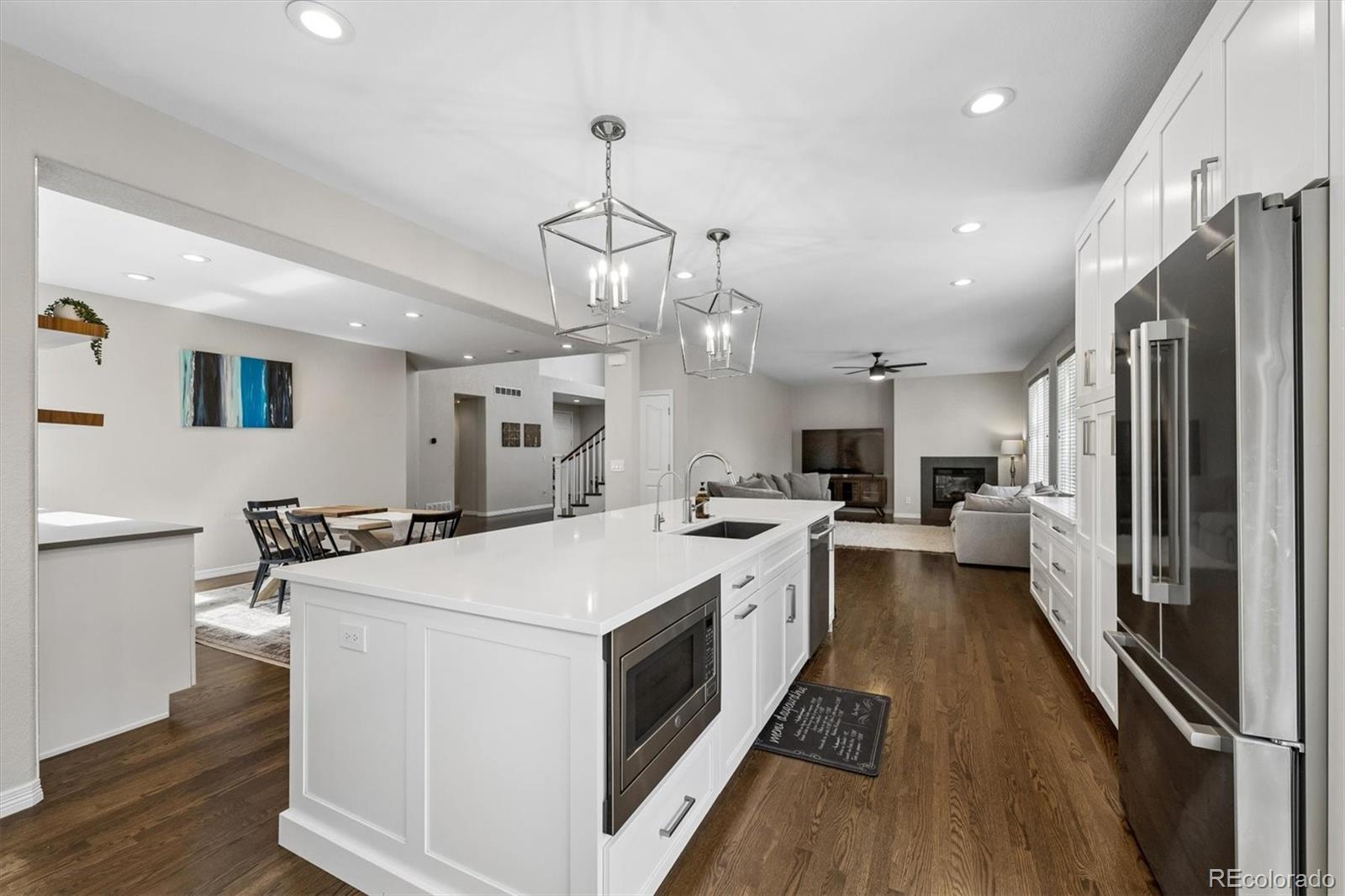 2677 Pemberly Avenue Highlands Ranch, CO 80126 - Photo 14 of 50 a large kitchen with kitchen island a stove a sink a refrigerator and a chandelier