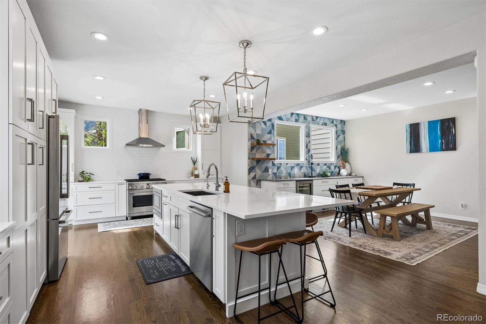 2677 Pemberly Avenue Highlands Ranch, CO 80126 - Photo 15 of 50 a kitchen with stainless steel appliances a dining table chairs stove and cabinets