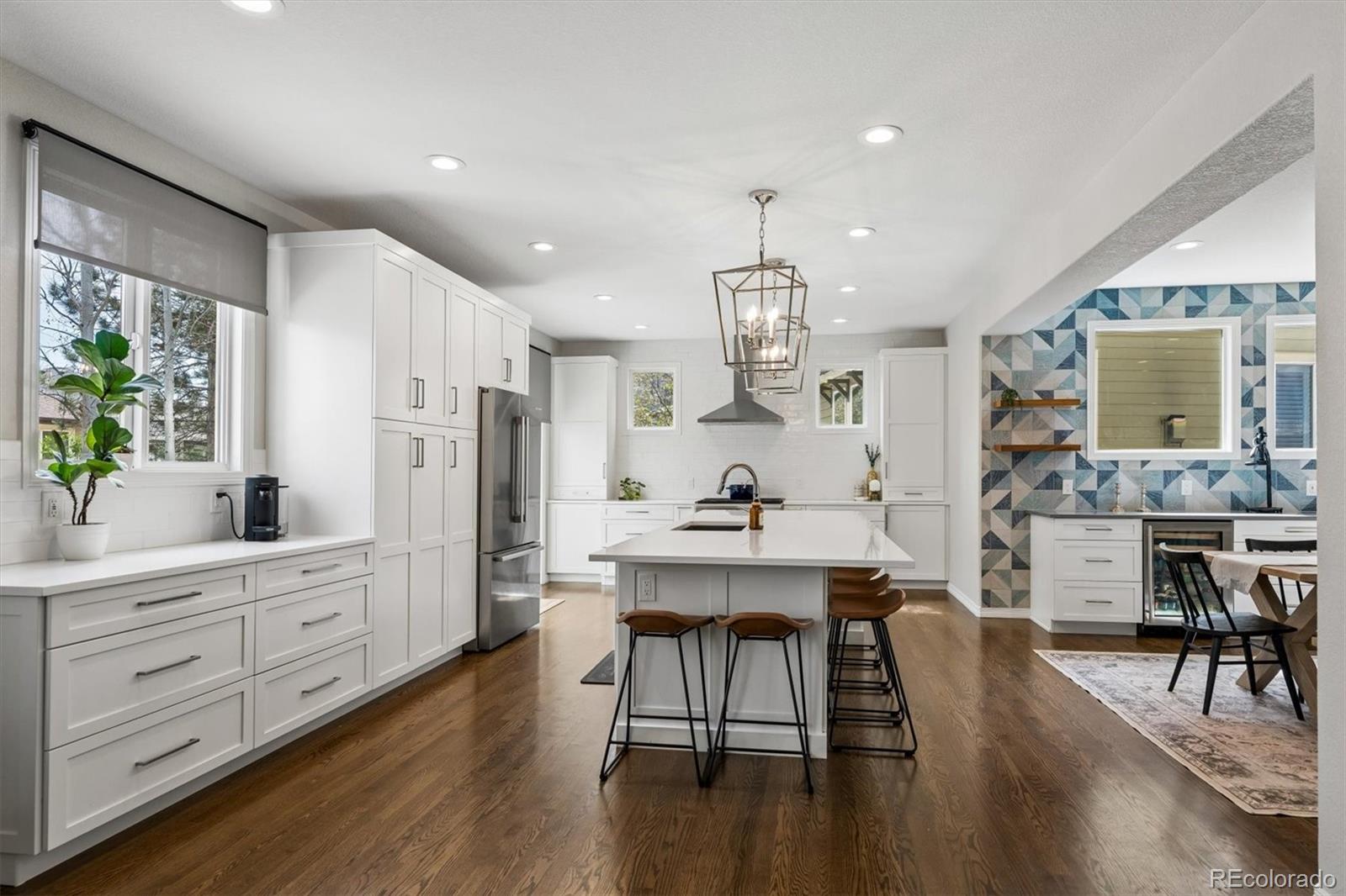 2677 Pemberly Avenue Highlands Ranch, CO 80126 - Photo 16 of 50 a kitchen with stainless steel appliances a dining table chairs stove refrigerator and cabinets