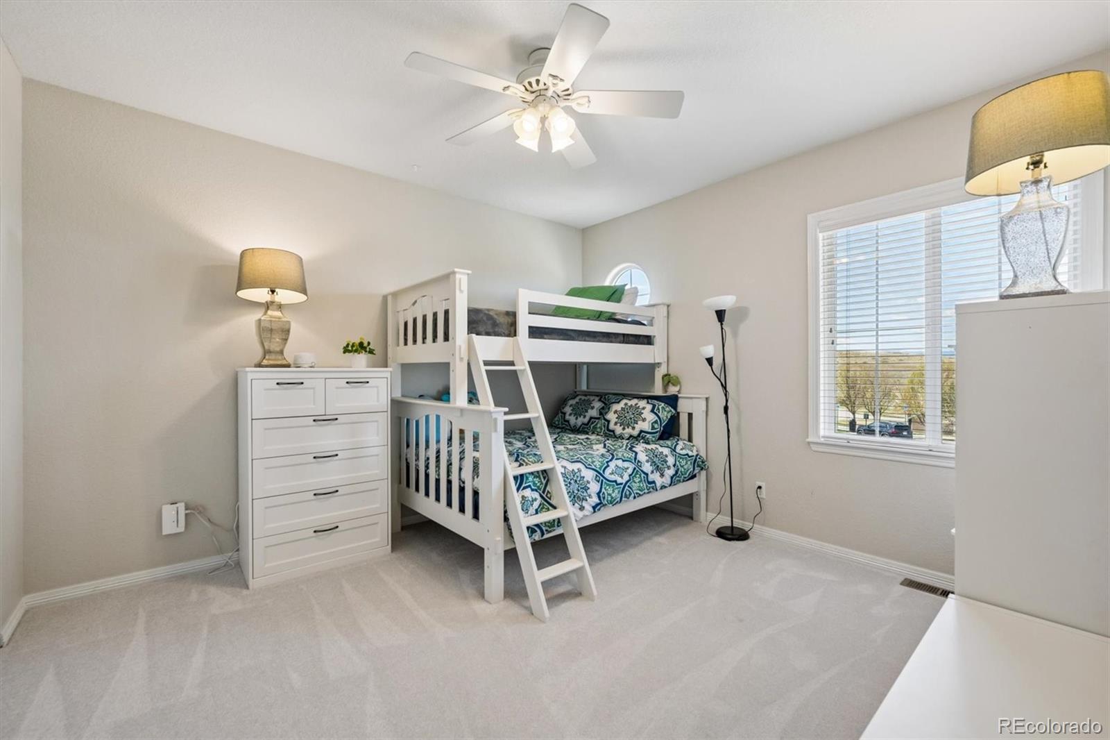 2677 Pemberly Avenue Highlands Ranch, CO 80126 - Photo 30 of 50 a bedroom with a bed and a chandelier